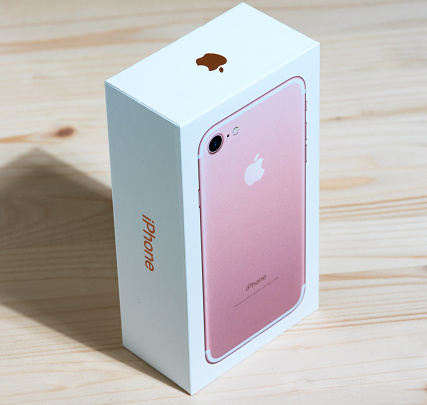 istanbul, Turkey - December 10, 2016:Brand new Rose gold Apple iPhone 7 smart phone in it's box on wooden background.