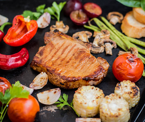 istock Steak on the bone with vegetables cooked  the grill. Black 629247770