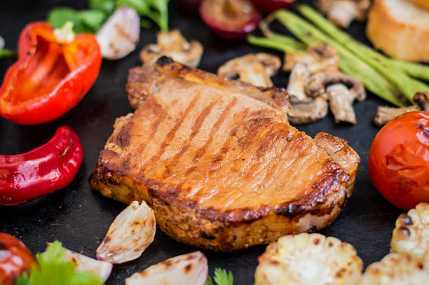 istock Steak on the bone with vegetables cooked  the grill. Black 629247852
