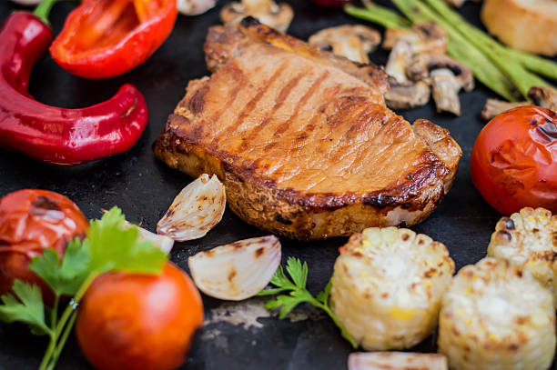 Steak on the bone with vegetables cooked  the grill. Black