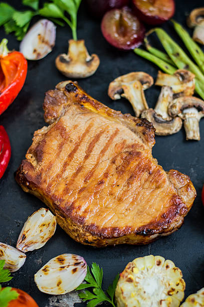 istock Steak on the bone with vegetables cooked  the grill. Black 629248006
