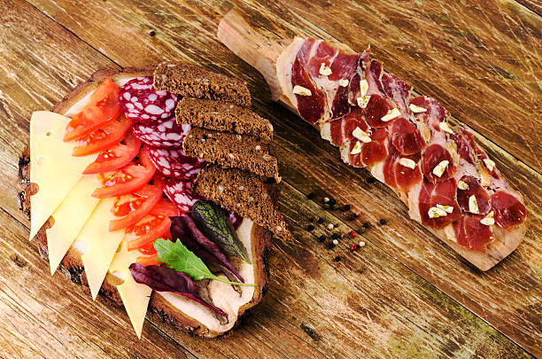 Tomatoes, salami, cheese and bread on a stump.
