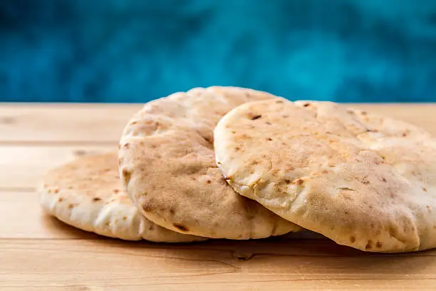 Pita, Arabic bread, soft baked flatbreads on wooden background, selective focus