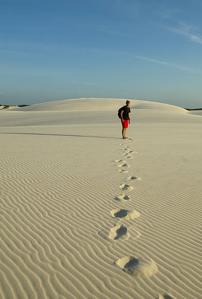 istock Man walking in the desert, leaving footsteps behind. 629254824