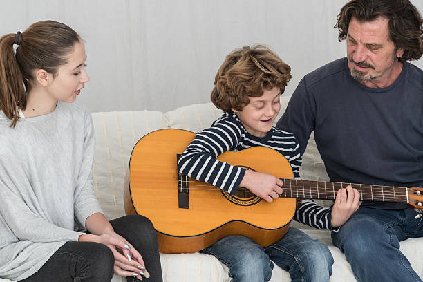istock Father teaching his children how to play guitar 629256622