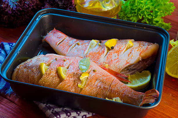 istock raw sea bass in a baking 629256884