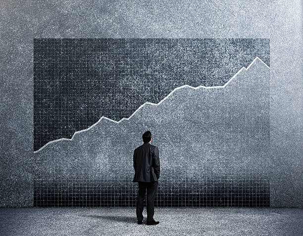 istock Businessman Looking Up At Growth Chart On Wall 629264246