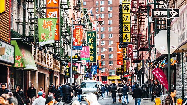 Streets of Chinatown in New York City. People walking in one of the colourful streets in NY Chinatown. chinatown photos stock pictures, royalty-free photos & images