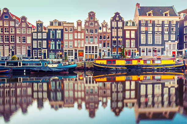 Amsterdam canal Singel with dutch houses Amsterdam canal Singel with typical dutch houses and houseboats during morning blue hour, Holland, Netherlands. Used toning embankment photos stock pictures, royalty-free photos & images
