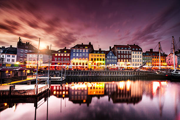 Copenhagen famous canal with boats and typical architecture View of Copenhagen famous canal with boats and houses during a beautiful sunset. nyhavn stock pictures, royalty-free photos & images