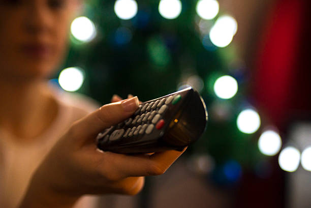 Christmas TV, woman aiming remote control