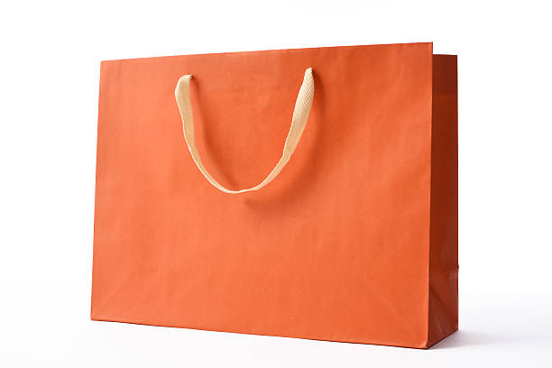 isolierte aufnahme von orange farbe einkaufstasche auf weißem hintergrund - shopping bag orange bag handle stock-fotos und bilder