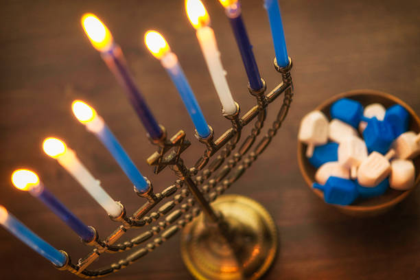 menora z płonącymi świecami i dreidel. preparaty do chanuka - hanukkah menorah candle blue zdjęcia i obrazy z banku zdjęć