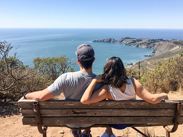 istock Young couple sitting on bench enjoying fantastic ocean view 629296428