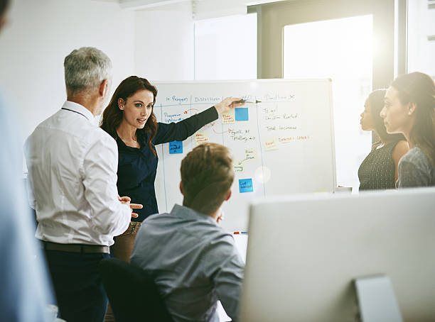 Take a look Shot of a group of business colleagues meeting in an office whiteboard visual aid stock pictures, royalty-free photos & images