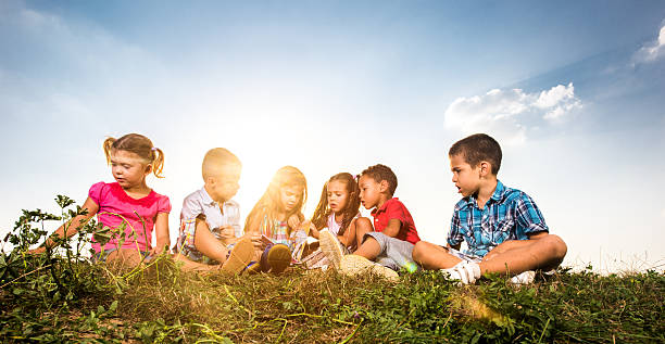 istock Small kids reading a children's book in nature. 629296692