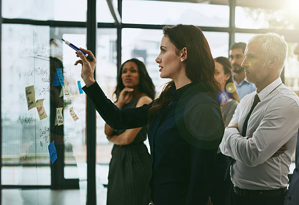 Leading the planning process Shot of a group of business colleagues meeting in the boardroom men standing business formalwear stock pictures, royalty-free photos & images