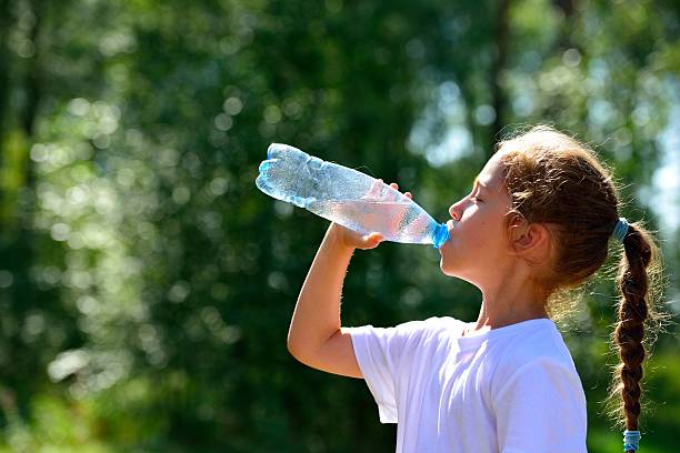 istock Cute child drinking water from a bottle 629304288