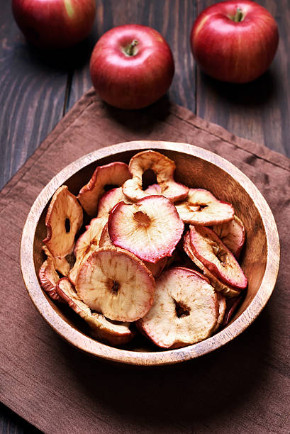 istock Dehydrated apples chips in wooden bowl 629305234