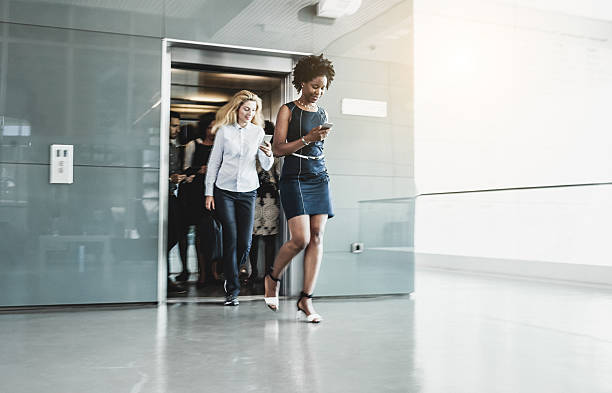 des gens d’affaires sortant de l’ascenseur - departure hall photos et images de collection