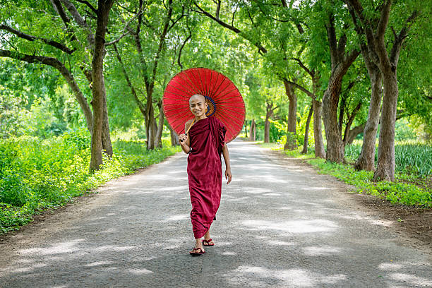 istock Novice Monk walking along Green Tree  Alley Bagan Myanmar 629321358