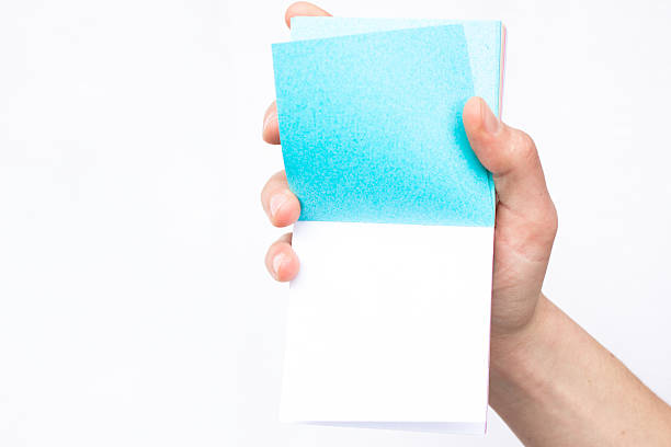 istock Hand holds notebook open. Blank white paper. Place for an 629322376