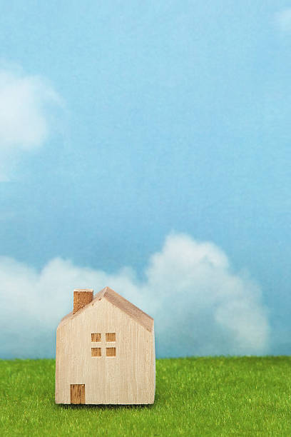 istock House on green grass over blue sky and clouds. 629323670