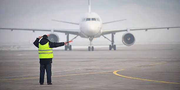 Photo of airport worker signaling