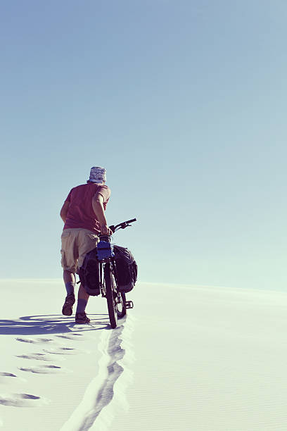 istock Traveling man on a bicycle in the desert. 629338580