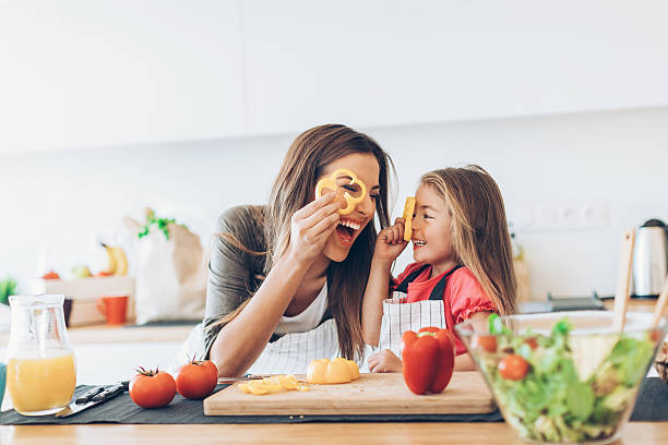 madre e hija divirtiéndose con las verduras - plato de comida fotos fotografías e imágenes de stock