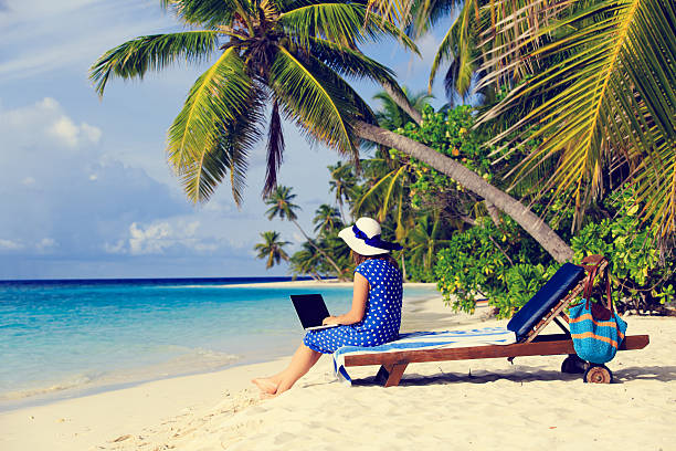 istock remote work cocept -young woman with laptop on tropical beach 629354170