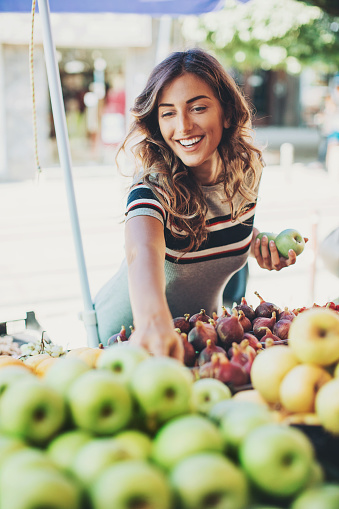 Attractive woman choosing fruits on the farmer's market.