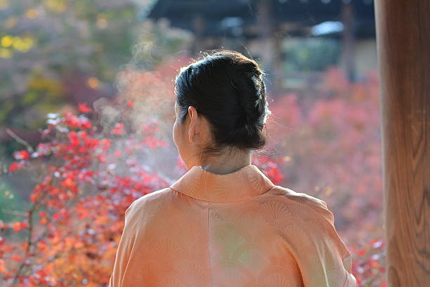Japanese woman in kimono breathing white at Tofuku-ji Temple stock photo