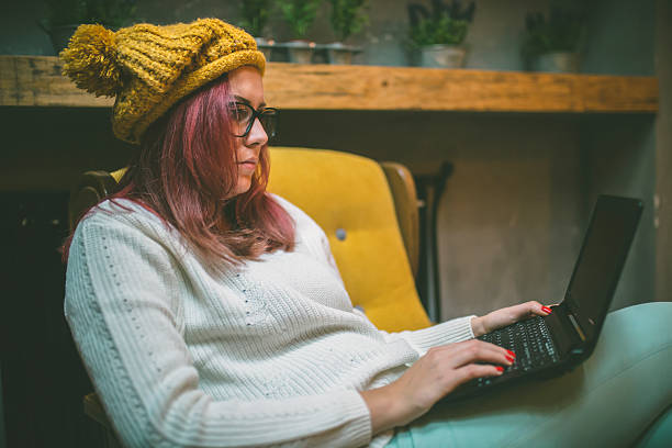 istock Hipster woman sitting on armchair using a laptop 629355948