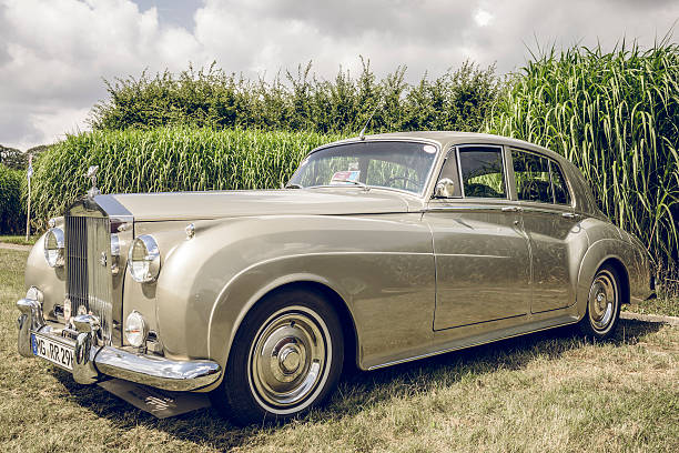 Rolls-Royce Silver Cloud I luxury saloon car Jüchen, Germany - August 5, 2016: Rolls-Royce Silver Cloud I luxury British saloon car. The Silver Cloud was produced  from April 1955 to March 1966 by Rolls Royce Limited. The car is on display during the 2016 Classic Days at castle Dyck. The car is displayed in a field, with people looking at the cars in the background. rolls royce stock pictures, royalty-free photos & images