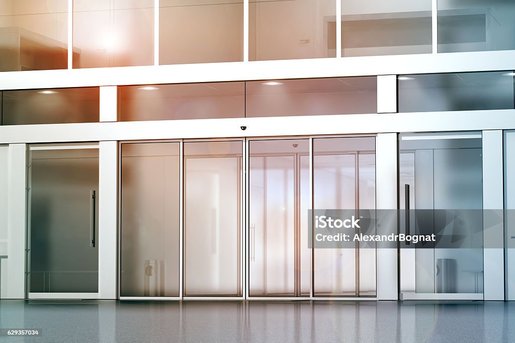 Blank sliding glass doors entrance mockup Blank sliding glass doors entrance mockup, 3d rendering. Commercial building entry mock up. Office exterior outdoor template. Emporium facade on sunset, front view. Sunny shopping center. Door Stock Photo