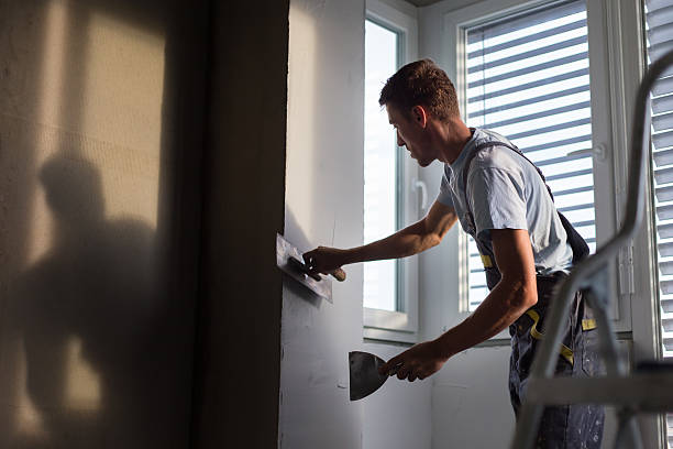 Plasterer renovating indoor walls and ceilings. Construction finishing works.