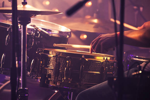 Drummer plays on drum set, vintage Vintage toned live music background, drummer plays with drumsticks on rock drum set. Closeup photo with soft selective focus drummer hands stock pictures, royalty-free photos & images