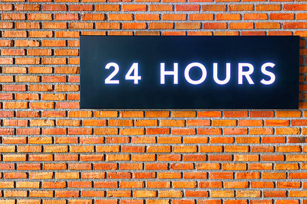 istock Twenty four hours glowing sign on  brick wall 629364236