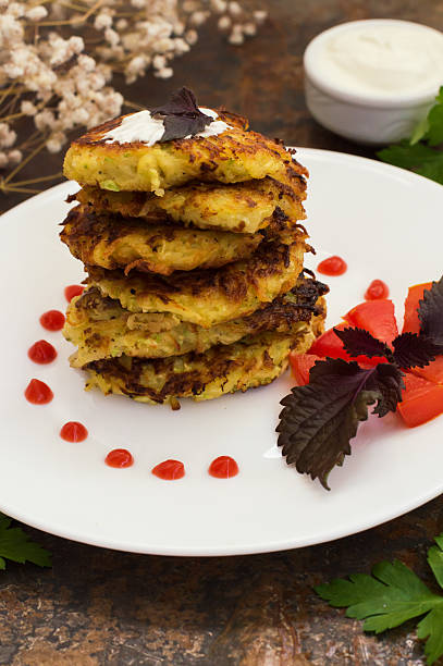 istock Zucchini Pancakes with sour cream, tomatoes and herbs. Old background 629367490