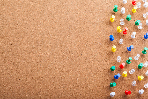 Group of thumbtacks pinned on corkboard Group of thumbtacks pinned on corkboard bulletin board stock pictures, royalty-free photos & images
