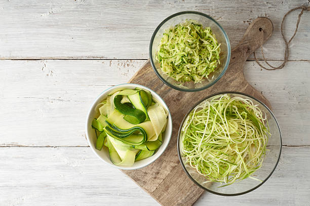 Raw zucchini noodles on the white wooden table top view stock photo