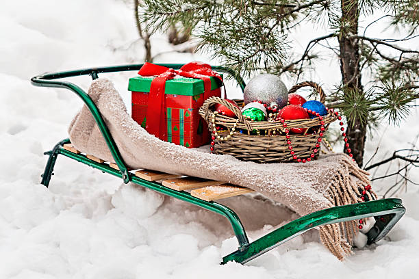 istock sledges, blanket, basket with toys and gift boxes in  snowy 629368280