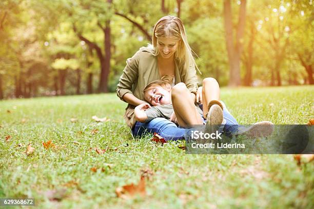Mother With Her Daughter In The Park Stock Photo - Download Image Now - Grass, Mother, Blond Hair