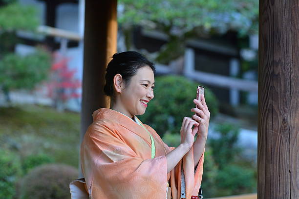 Japanese woman in kimono taking selfie at Tofuku-ji Temple, Kyoto stock photo