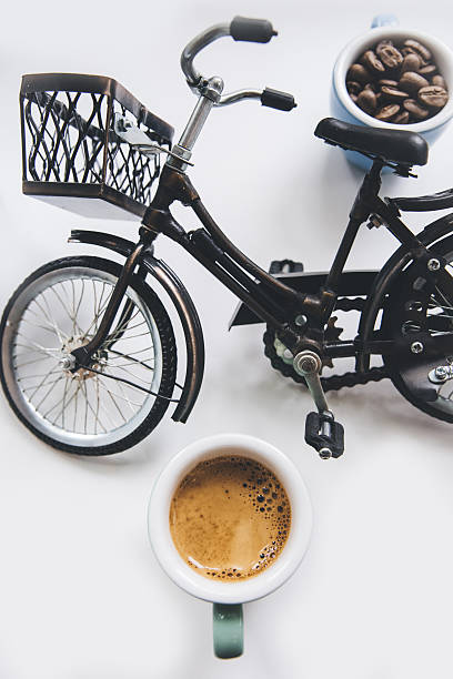 Coffee beans and fresh espresso coffee and a miniature bicycle
