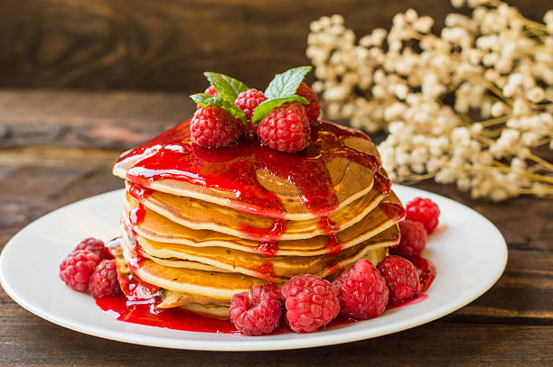 istock Pancakes with raspberry jam and fresh berries. Wooden background. Close 629375552