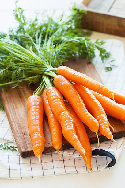 istock raw carrot vegetable on wooden chopping board 629376058