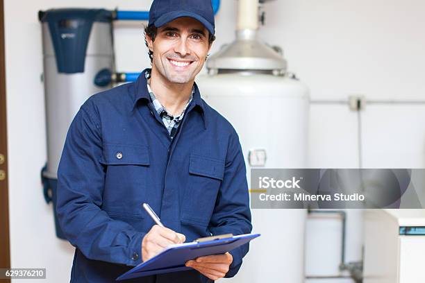 Technician Servicing An Hotwater Heater Stock Photo - Download Image Now - Plumber, Boiler, Technician