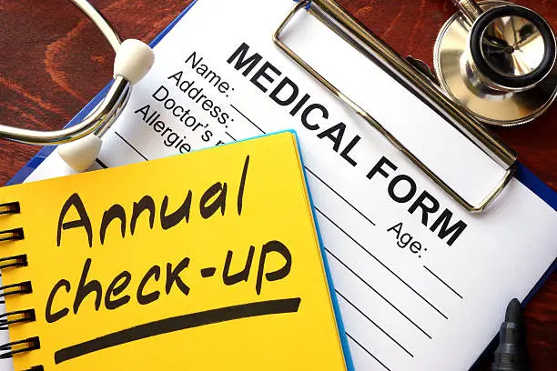 Photo of Annual check-up in a note and medical form.